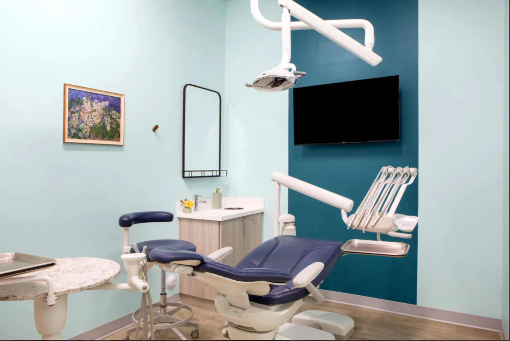 A treatment room with a screen at Mint Leaf Dentistry